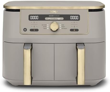 The Ninja MAX Dual Zone Air Fryer in Stone Gold showing two independent cooking drawers partially open with golden chips inside.